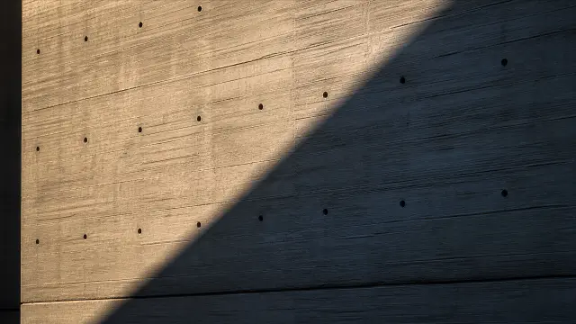 Pared de hormigón con luces y sombras al atardecer