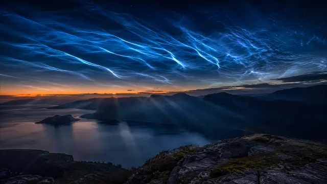 Nubes de rayos auroras sobre fiordo al atardecer