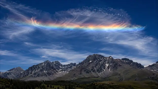 Nubes arcoiris sobre montanas nevadas