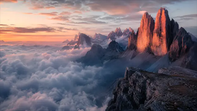 Picos de montaña al amanecer sobre nubes