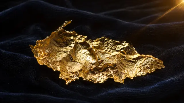 Trozo de oro brillante sobre tela negra