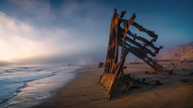 Hundido en la playa al atardecer