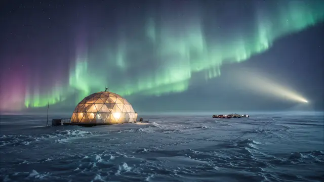 Domo iluminado bajo la aurora boreal en el Ártico