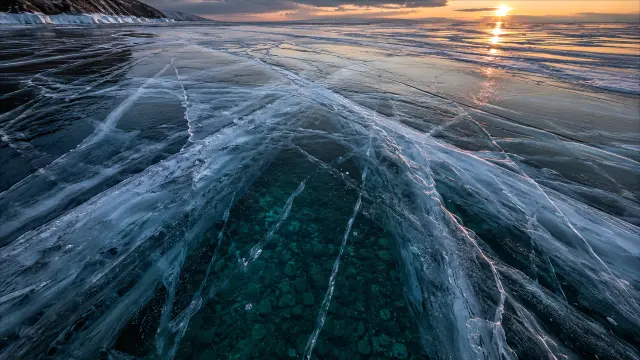 Lago congelado al atardecer con hielo transparente