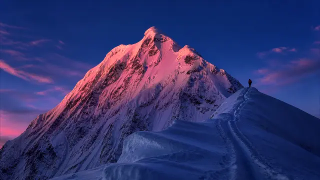 Paisaje de montaña nevada al atardecer con esquiador