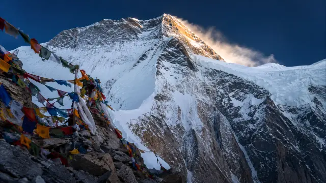 Montaña nevada con banderas tibetanas al amanecer