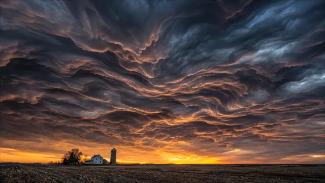 Cielo tormentoso sobre campo al atardecer