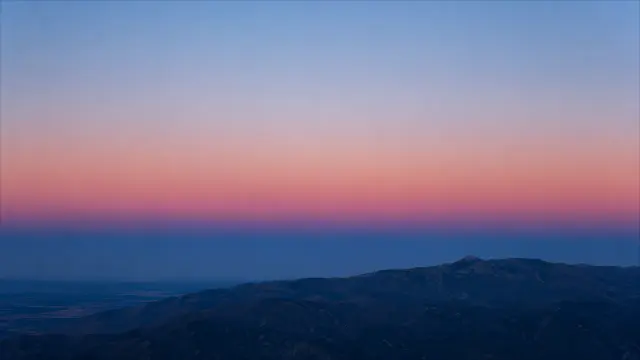Atardecer en montañas con cielo rosa y azul profundo
