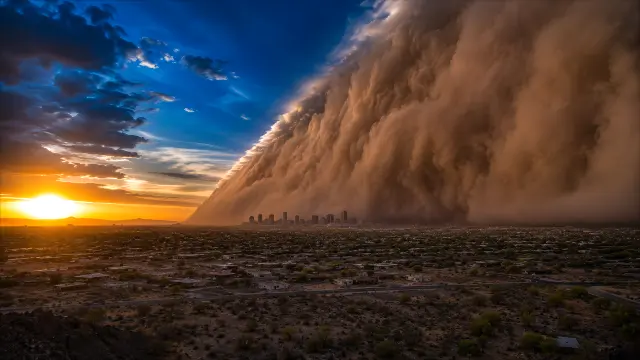Inminente pared de polvo sobre ciudad al atardecer