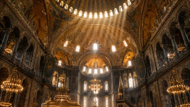 Interior de Basílica con cúpula dorada y mosaicos antiguos.